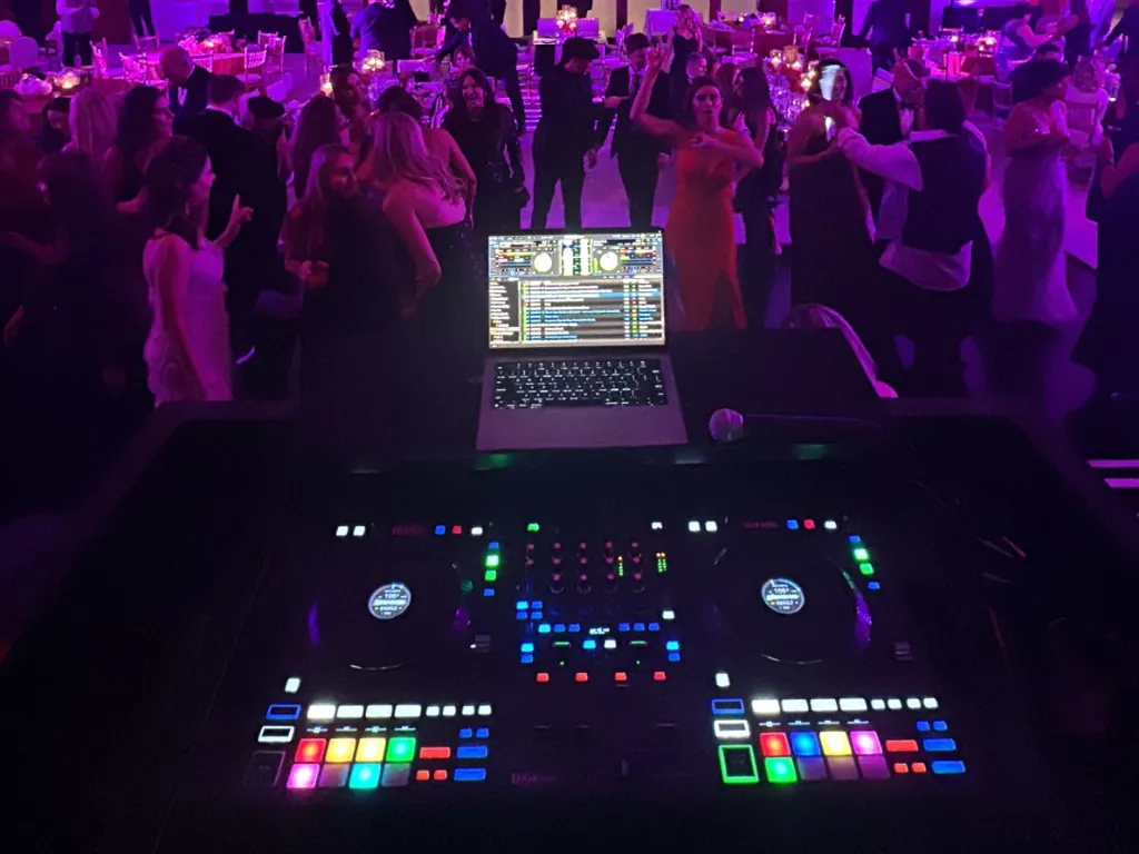 The view from DJ Lowso’s controller over a full dance floor in a ballroom lit purple at Balboa Bay Resort in Newport Beach