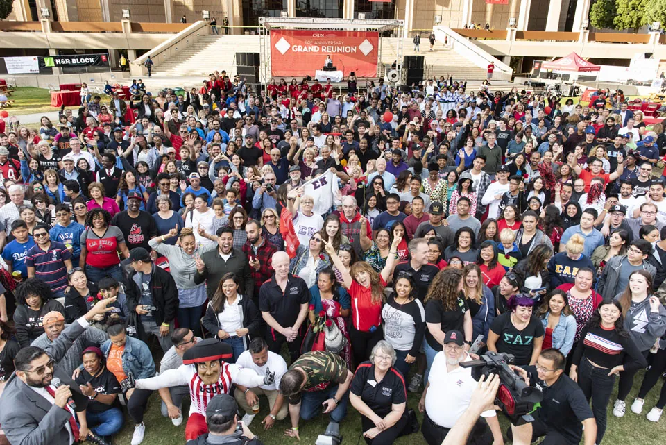 A large outdoor crowd at the CSUN Grand Reunion in front of the event stage