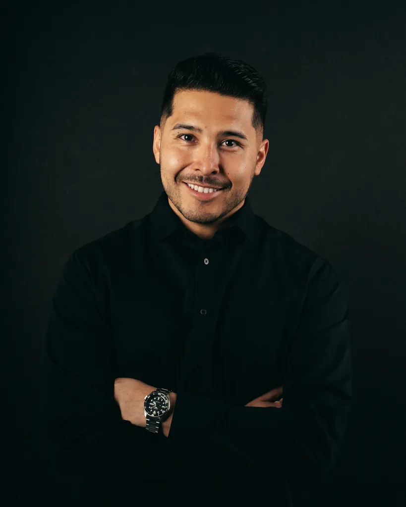 Fabian, DJ Lowso, smiling with his arms crossed against a dark background