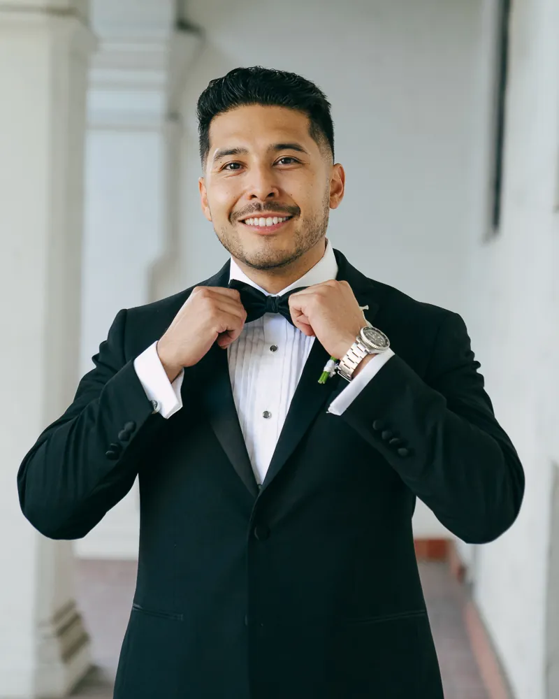 Fabian, DJ Lowso, in a tuxedo adjusting his bow tie