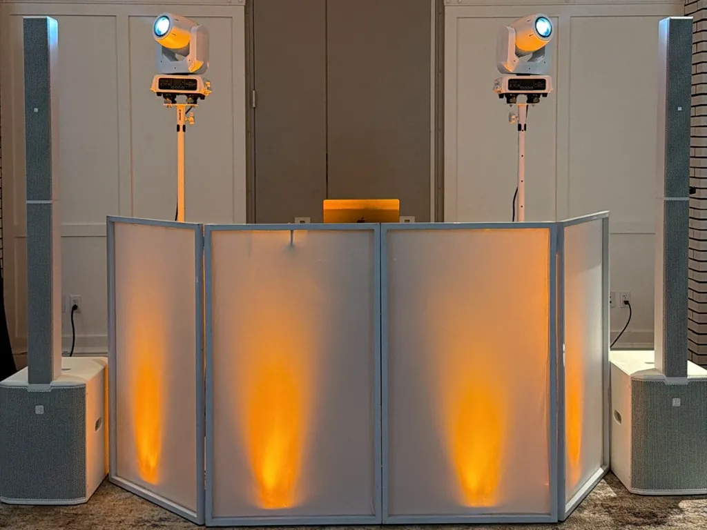 DJ Lowso’s all-white booth with column speakers, two moving-head lights, and amber uplighting at Lido House in Newport Beach