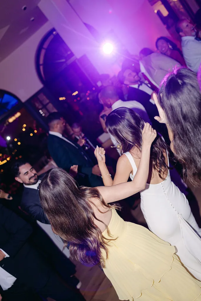 Dance floor lit in purple and magenta at a wedding reception